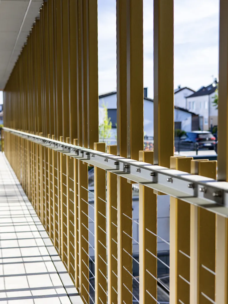 Fassade aus gekantetem Stahlblech mit Edelstahlseilgeländer